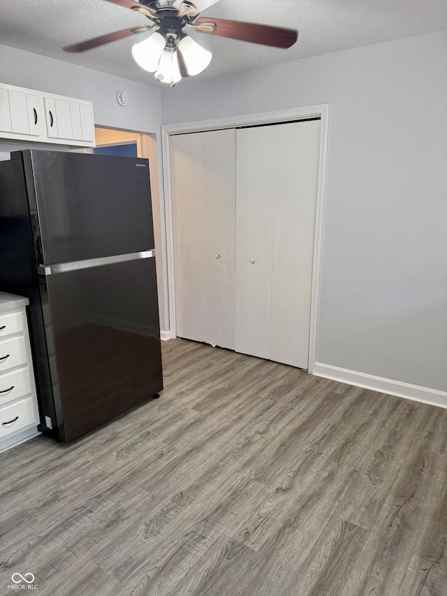 4024 Zinfandel Way, Indianapolis, IN 46254 - kitchen featuring freestanding refrigerator, ceiling fan, light wood finished floors, and white cabinetry