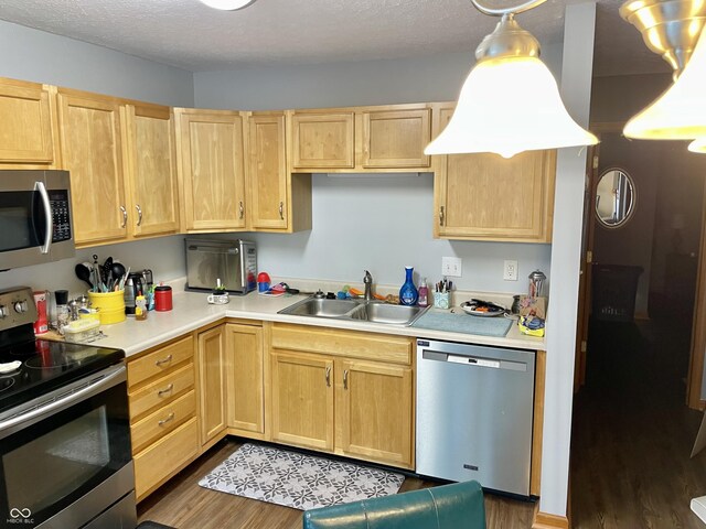 6191 Wildcat Dr, Indianapolis, IN 46203 - kitchen with stainless steel appliances, light brown cabinetry, dark wood finished floors, light countertops, and a textured ceiling