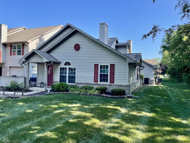 6191 Wildcat Dr, Indianapolis, IN 46203 - view of front facade featuring a front lawn, a chimney, and roof with shingles