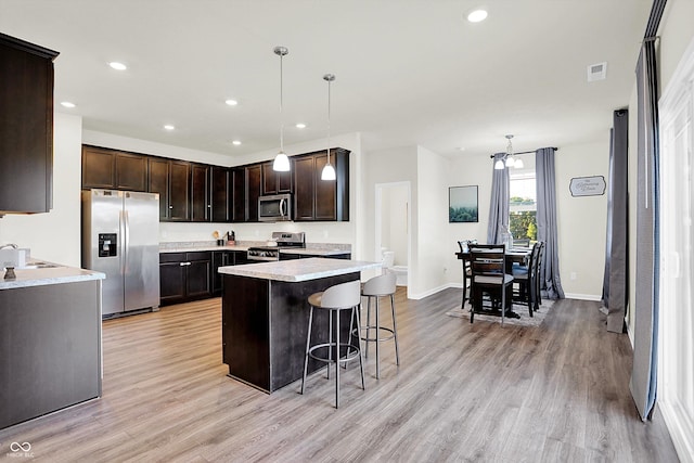 2738 Pointe Club Rd, Indianapolis, IN 46229 - kitchen with stainless steel appliances, light wood-type flooring, dark brown cabinets, light countertops, and a kitchen breakfast bar