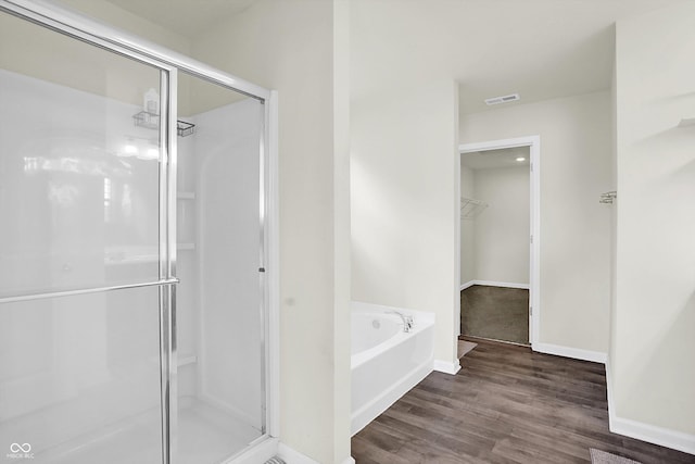2738 Pointe Club Rd, Indianapolis, IN 46229 - bathroom featuring a shower stall, a garden tub, wood finished floors, and a spacious closet