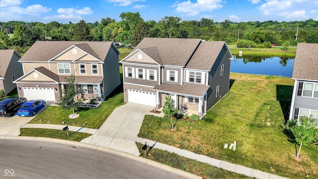 2738 Pointe Club Rd, Indianapolis, IN 46229 - view of front facade featuring driveway, an attached garage, a front lawn, roof with shingles, and a water view