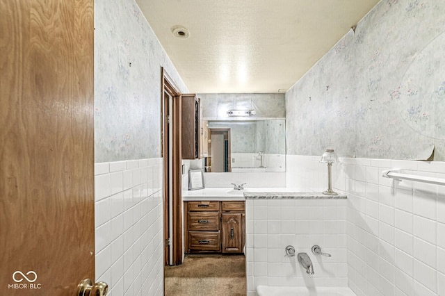 6241 S Meridian St, Indianapolis, IN 46217 - full bathroom featuring tile walls, a bath, vanity, a wainscoted wall, and wallpapered walls