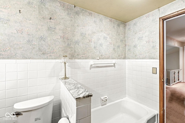 6241 S Meridian St, Indianapolis, IN 46217 - bathroom with wallpapered walls, wainscoting, a tub to relax in, and tile walls