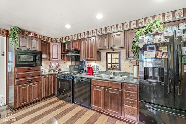 6241 S Meridian St, Indianapolis, IN 46217 - kitchen with black appliances, light wood-type flooring, beverage cooler, under cabinet range hood, and dark countertops