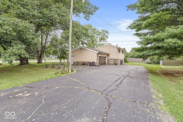 6241 S Meridian St, Indianapolis, IN 46217 - view of property exterior featuring an attached garage, driveway, and stone siding