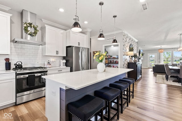 19677 Sumrall Pl, Westfield, IN 46074 - kitchen with appliances with stainless steel finishes, wall chimney exhaust hood, a center island, light countertops, and decorative backsplash