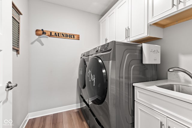 19677 Sumrall Pl, Westfield, IN 46074 - laundry room featuring washing machine and clothes dryer, cabinet space, and wood finished floors