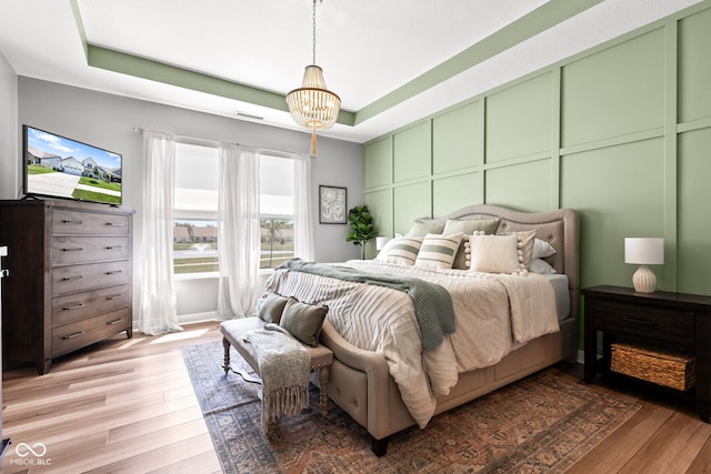 19677 Sumrall Pl, Westfield, IN 46074 - bedroom with wood finished floors, a tray ceiling, and a chandelier