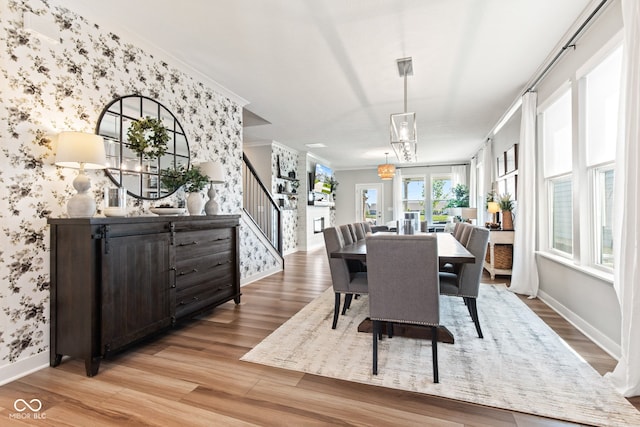 19677 Sumrall Pl, Westfield, IN 46074 - dining space featuring wallpapered walls, light wood finished floors, crown molding, and stairway