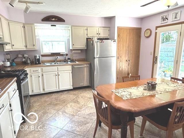 11 Mccutcheon Dr, Lafayette, IN 47909 - kitchen featuring appliances with stainless steel finishes, range hood, light tile patterned floors, and a ceiling fan