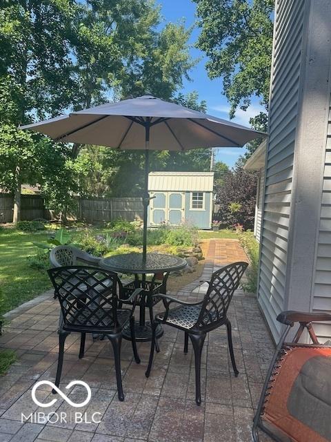 11 Mccutcheon Dr, Lafayette, IN 47909 - fenced backyard featuring outdoor dining space, a storage shed, and a patio