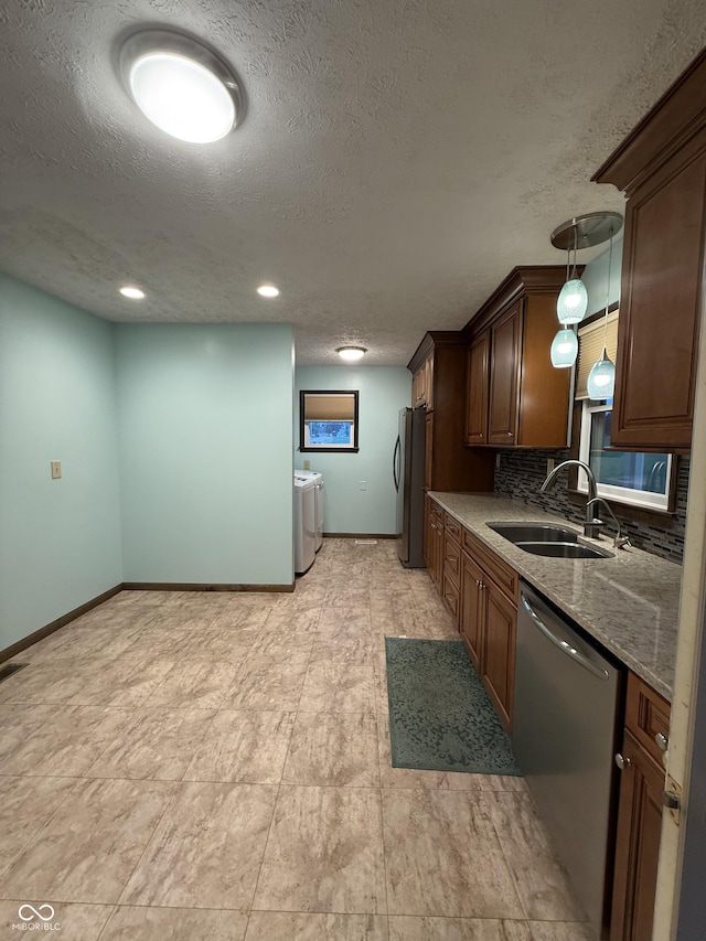 11698 N Bethesda Rd, Mooresville, IN 46158 - kitchen with washer and clothes dryer, appliances with stainless steel finishes, a textured ceiling, backsplash, and hanging light fixtures