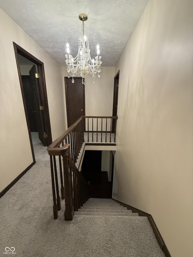 11698 N Bethesda Rd, Mooresville, IN 46158 - stairs featuring carpet floors, a chandelier, and a textured ceiling