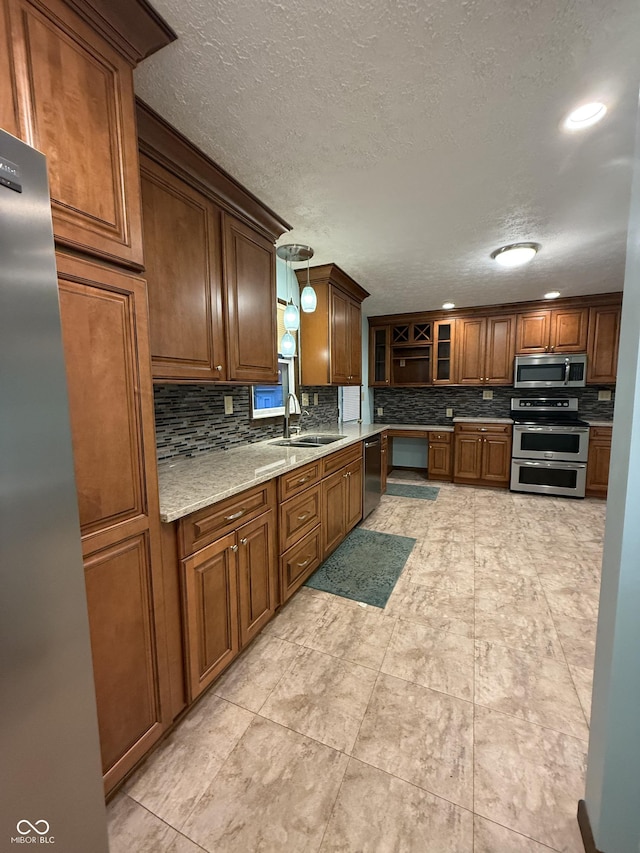11698 N Bethesda Rd, Mooresville, IN 46158 - kitchen featuring stainless steel appliances, tasteful backsplash, a textured ceiling, brown cabinets, and glass insert cabinets