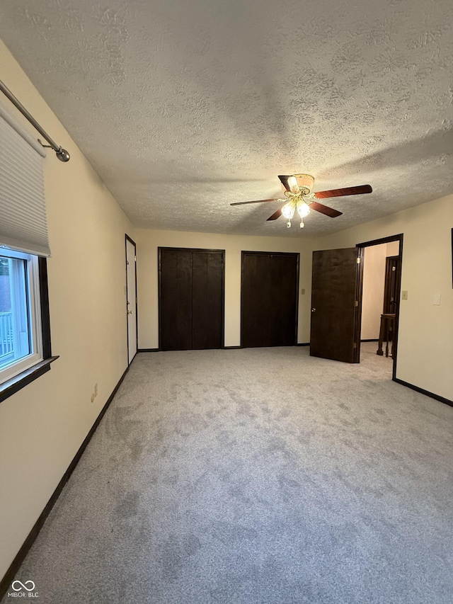 11698 N Bethesda Rd, Mooresville, IN 46158 - unfurnished bedroom with a textured ceiling, two closets, light carpet, and a ceiling fan