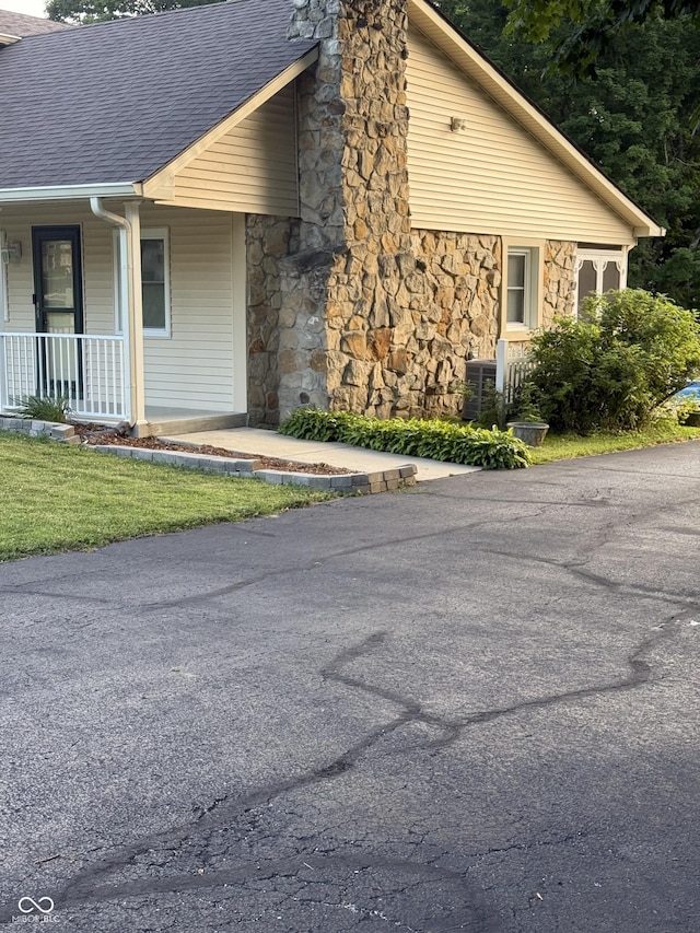 11698 N Bethesda Rd, Mooresville, IN 46158 - view of side of property featuring stone siding, roof with shingles, and a porch