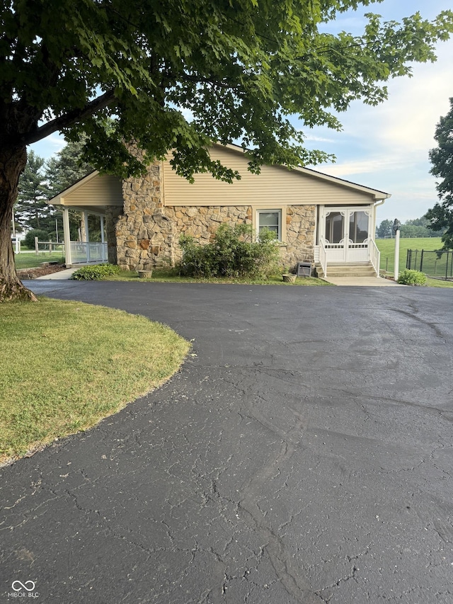 11698 N Bethesda Rd, Mooresville, IN 46158 - view of front of home featuring stone siding, asphalt driveway, a front lawn, and covered porch