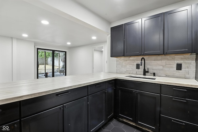 8138 Harrison Dr, Lawrence, IN 46226 - kitchen with tasteful backsplash, recessed lighting, dark tile patterned floors, light stone countertops, and a peninsula