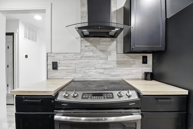 8138 Harrison Dr, Lawrence, IN 46226 - kitchen with stainless steel range with electric cooktop, wall chimney range hood, decorative backsplash, and wood counters