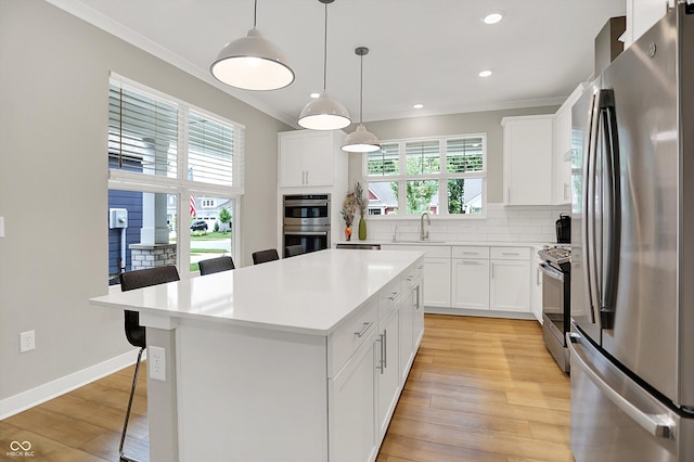 355 Ehrlich Ln, Westfield, IN 46074 - kitchen with stainless steel appliances, crown molding, a breakfast bar, plenty of natural light, and light countertops