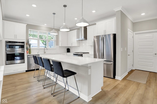 355 Ehrlich Ln, Westfield, IN 46074 - kitchen featuring stainless steel appliances, wall chimney range hood, ornamental molding, a breakfast bar, and backsplash