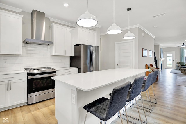 355 Ehrlich Ln, Westfield, IN 46074 - kitchen with appliances with stainless steel finishes, wall chimney exhaust hood, ornamental molding, tasteful backsplash, and light wood-style flooring