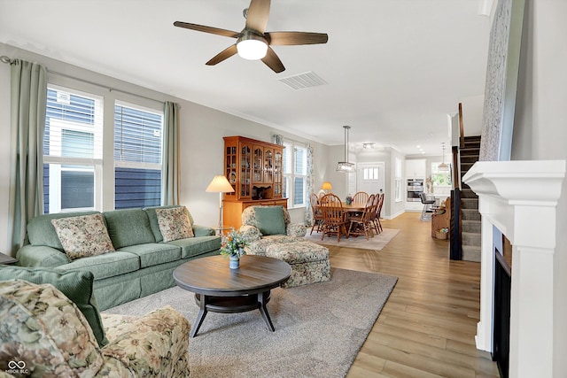 355 Ehrlich Ln, Westfield, IN 46074 - living room featuring ceiling fan, light wood finished floors, crown molding, and a fireplace