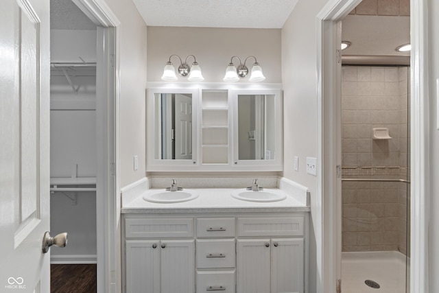 10184 Lakeshore Dr E, Carmel, IN 46033 - bathroom with double vanity, a walk in closet, a shower stall, and wood finished floors