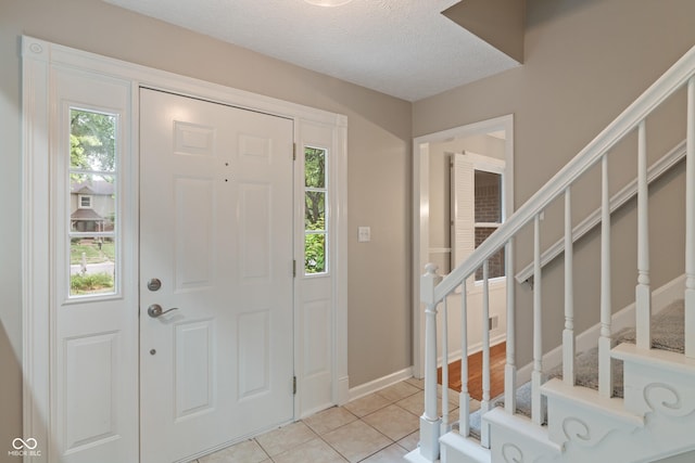 10184 Lakeshore Dr E, Carmel, IN 46033 - foyer with stairway, light tile patterned floors, and a textured ceiling