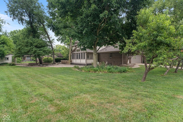 10184 Lakeshore Dr E, Carmel, IN 46033 - view of green lawn with a sunroom and an attached garage