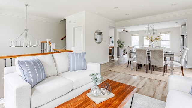 2570 Congress St, Carmel, IN 46032 - living area with a chandelier, light wood-style floors, ornamental molding, and ceiling fan