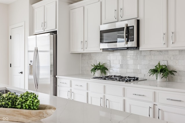 2570 Congress St, Carmel, IN 46032 - kitchen featuring stainless steel appliances, backsplash, white cabinets, and light stone countertops