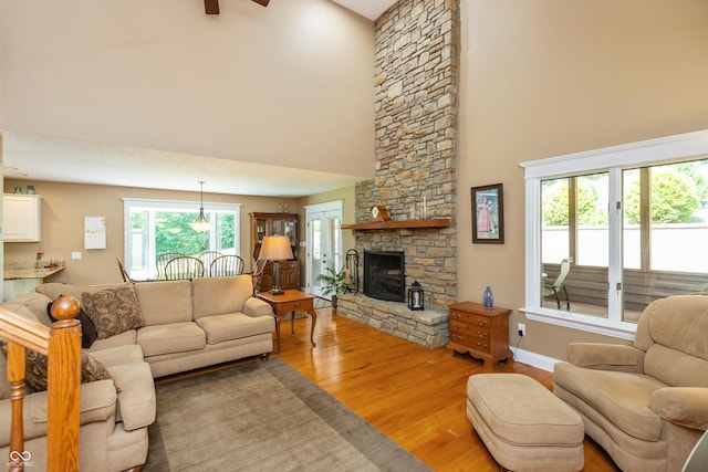 3750 S Whitehorse Rd, Nashville, IN 47448 - living area with light wood finished floors, a high ceiling, a stone fireplace, and ceiling fan