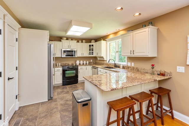3750 S Whitehorse Rd, Nashville, IN 47448 - kitchen with stainless steel appliances, a peninsula, recessed lighting, glass insert cabinets, and light stone countertops