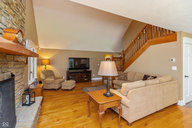 3750 S Whitehorse Rd, Nashville, IN 47448 - living area featuring light wood-style floors, stairway, high vaulted ceiling, and a stone fireplace