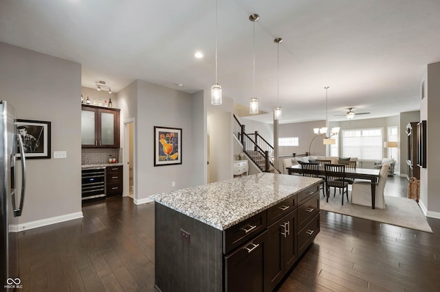 869 N Park Trail Dr, Carmel, IN 46032 - kitchen featuring stainless steel fridge with ice dispenser, light stone countertops, hanging light fixtures, dark wood-style flooring, and dark brown cabinets
