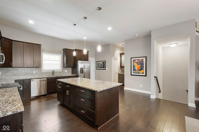 869 N Park Trail Dr, Carmel, IN 46032 - kitchen with stainless steel appliances, dark brown cabinets, decorative backsplash, a center island, and dark wood finished floors