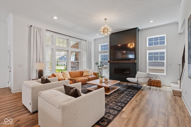 1275 Stonehaven Dr, Westfield, IN 46074 - living room featuring ornamental molding, a large fireplace, wood finished floors, a chandelier, and recessed lighting