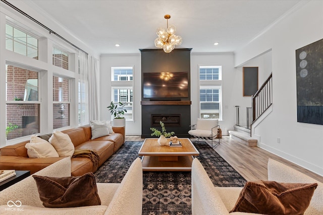 1275 Stonehaven Dr, Westfield, IN 46074 - living area featuring a large fireplace, plenty of natural light, stairs, crown molding, and wood finished floors