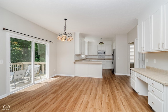 13722 Wendessa Dr, Fishers, IN 46038 - kitchen featuring appliances with stainless steel finishes, light wood-style flooring, white cabinets, and a peninsula