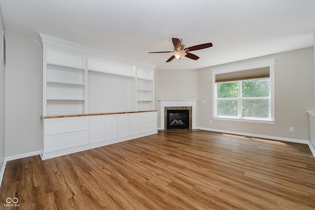 13722 Wendessa Dr, Fishers, IN 46038 - unfurnished living room with a ceiling fan, light wood-type flooring, and a tiled fireplace
