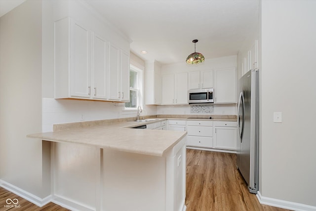 13722 Wendessa Dr, Fishers, IN 46038 - kitchen featuring appliances with stainless steel finishes, a peninsula, light wood-type flooring, light countertops, and recessed lighting