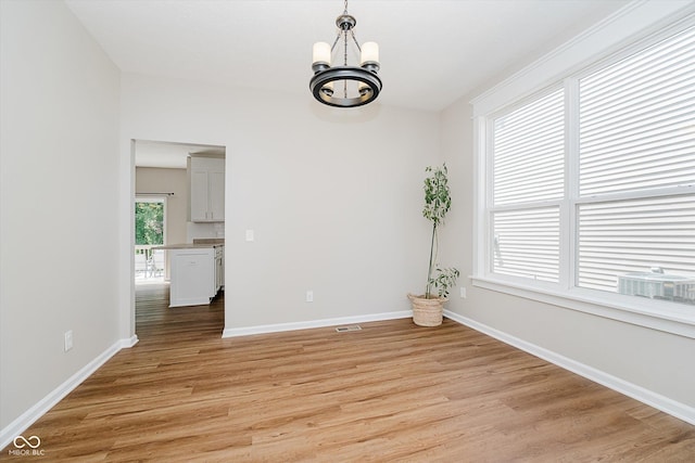 13722 Wendessa Dr, Fishers, IN 46038 - spare room with a chandelier and light wood-style floors