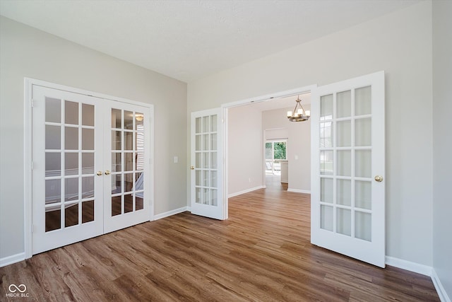 13722 Wendessa Dr, Fishers, IN 46038 - unfurnished room featuring french doors, wood finished floors, and a chandelier