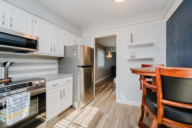 20 Druid Hill Ct, Carmel, IN 46032 - kitchen with stainless steel appliances, light wood-type flooring, backsplash, white cabinets, and light countertops