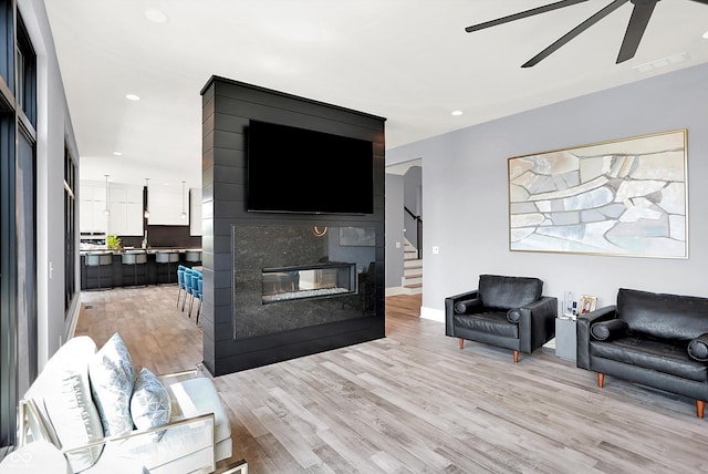 13417 Cambridge Cove Way, Fishers, IN 46055 - living room featuring ceiling fan, light wood-style floors, stairs, recessed lighting, and a fireplace