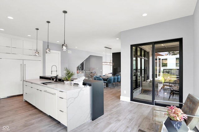 13417 Cambridge Cove Way, Fishers, IN 46055 - kitchen with modern cabinets, light wood-style floors, recessed lighting, an island with sink, and white cabinetry