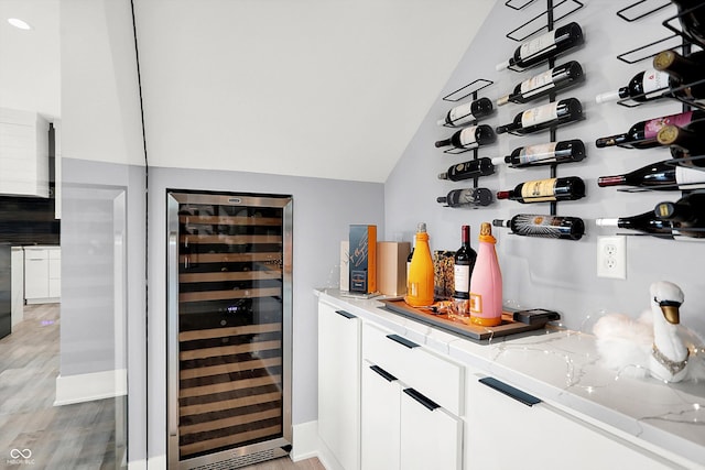 13417 Cambridge Cove Way, Fishers, IN 46055 - wine cellar featuring wine cooler, vaulted ceiling, light wood-type flooring, and bar area