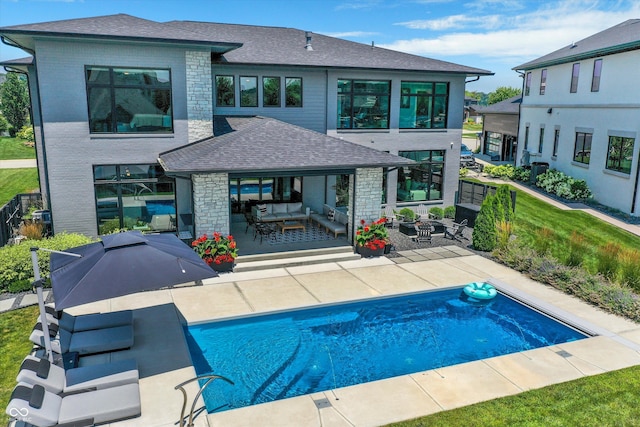 13417 Cambridge Cove Way, Fishers, IN 46055 - rear view of house featuring a patio, a shingled roof, an outdoor hangout area, stone siding, and an outdoor pool